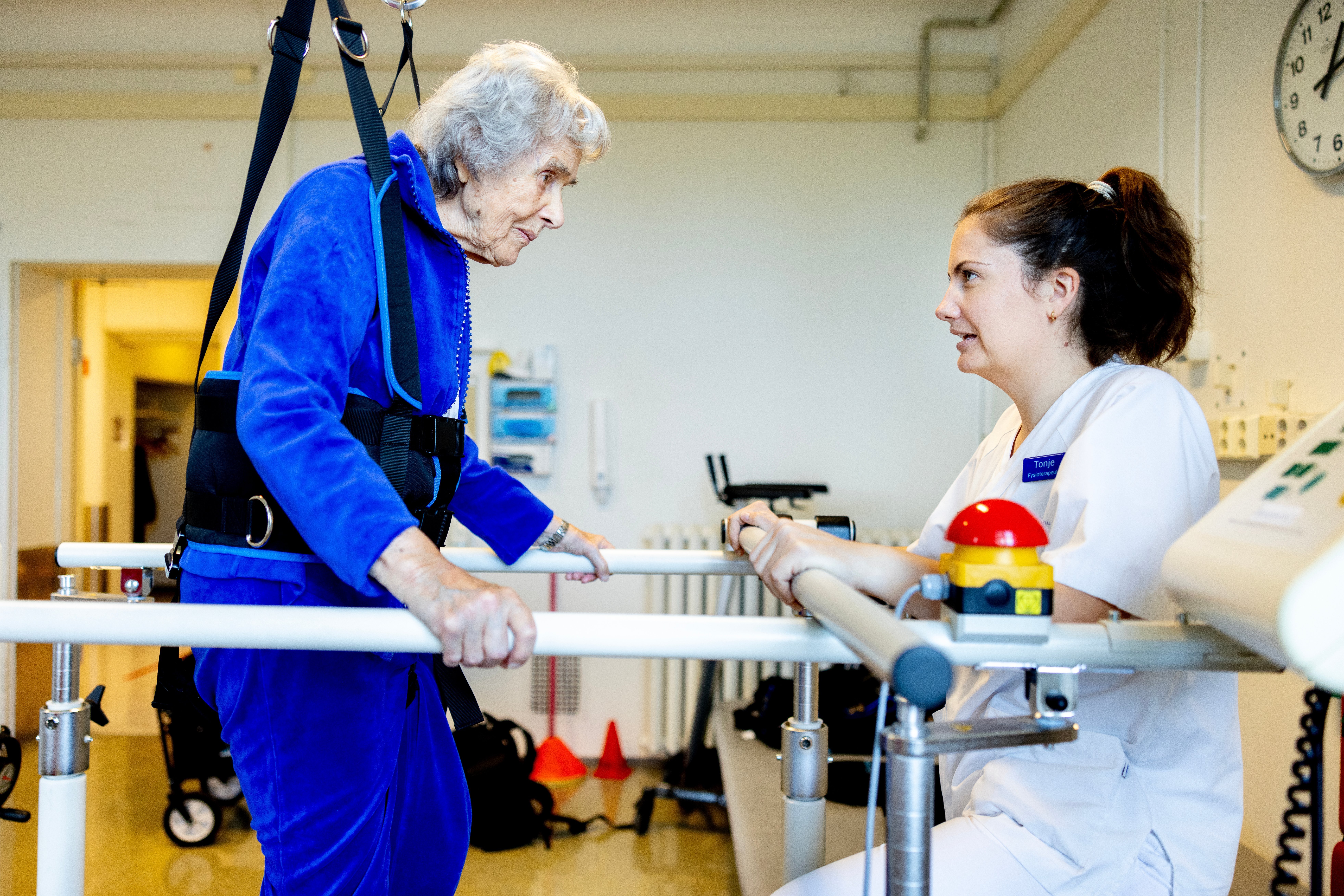 Bobilde eldre kvinne i gåstol med fysio